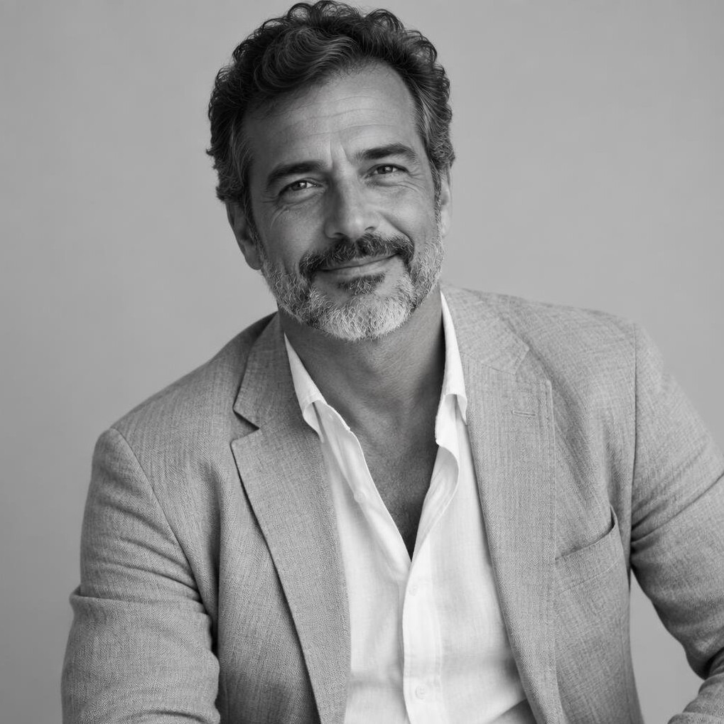 Studio portrait of a Brazilian man in his fifties, senior investment advisor in a linen blazer